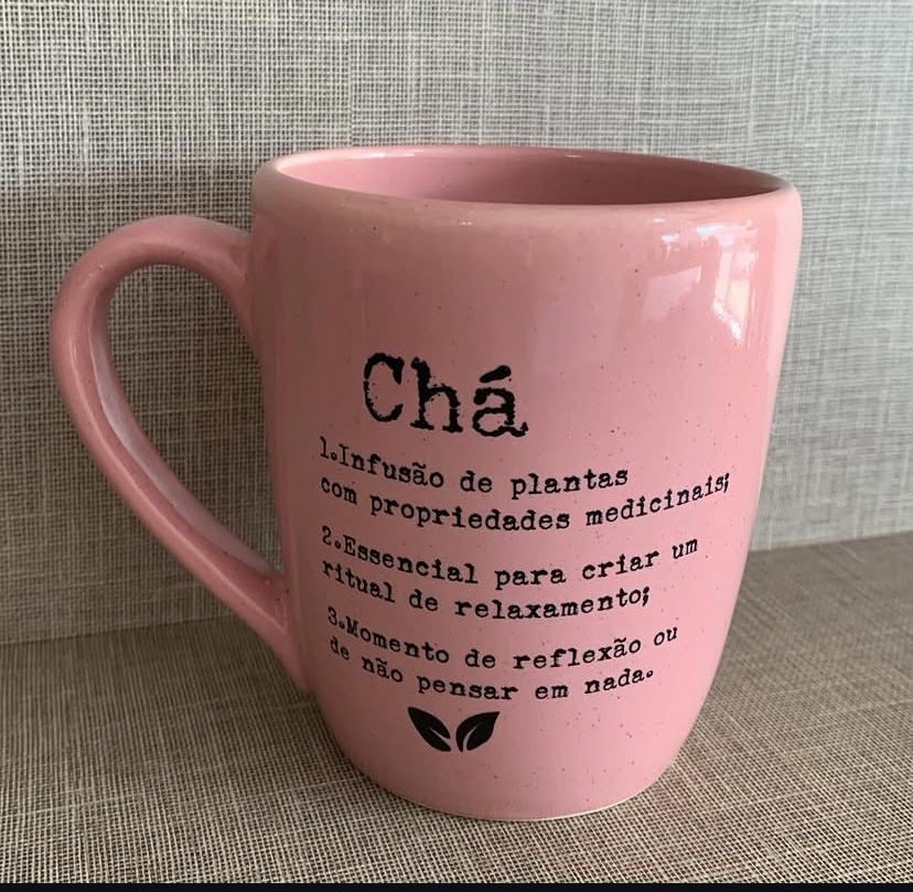 Caneca rosa com texto sobre chá: infusão de plantas, ritual de relaxamento