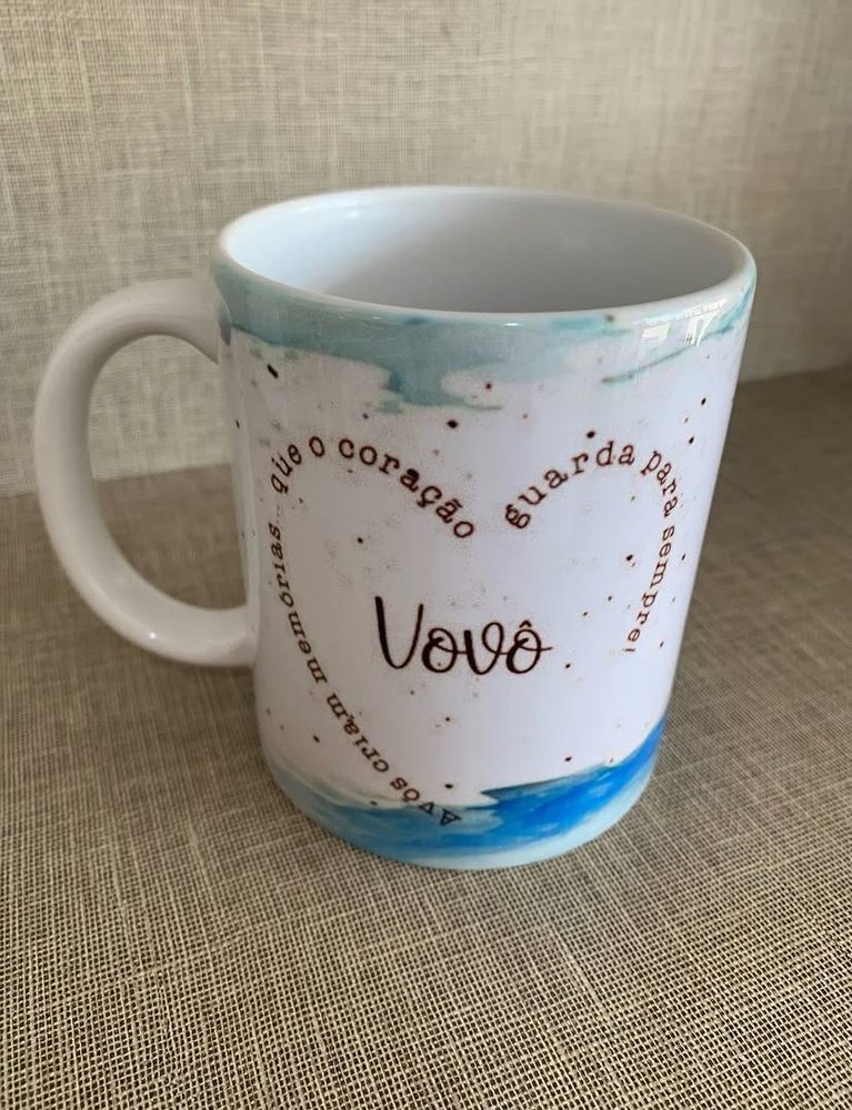 Caneca branca com coração desenhado e a palavra Vovô, fundo em aquarela azul