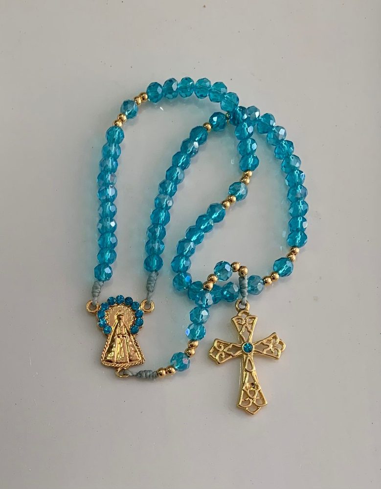Terço de cristais azul turquesa com medalha dourada de Nossa Senhora Aparecida